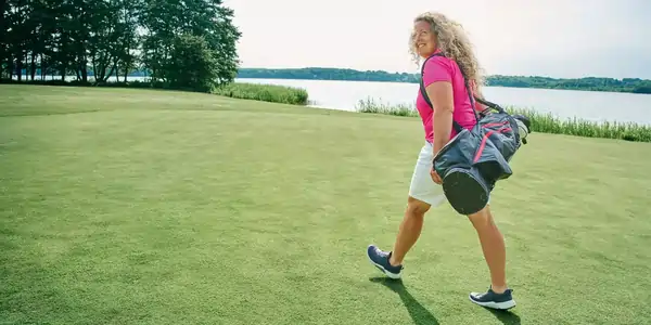 Fanny Sunesson walking the fairway carrying a golf bag
