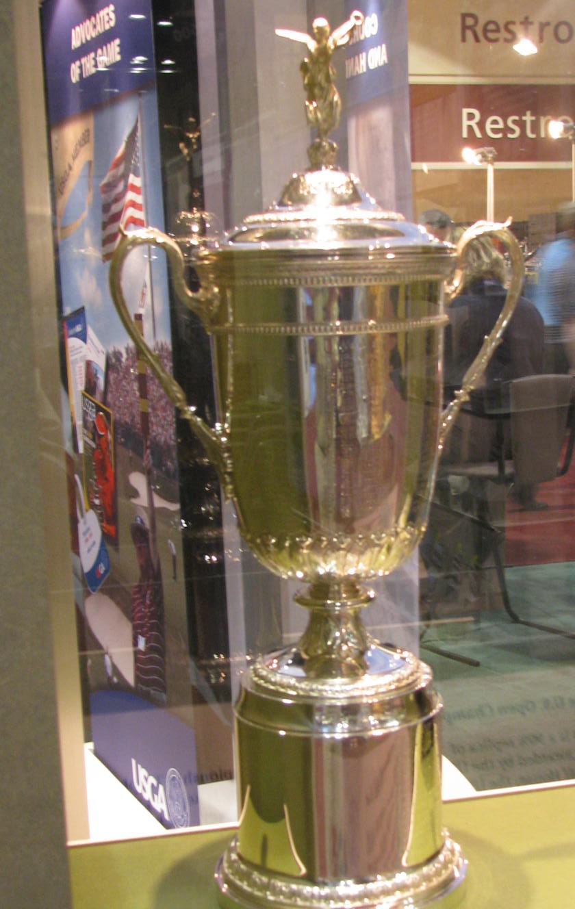 A replica of the U.S. Open golf trophy in a display case